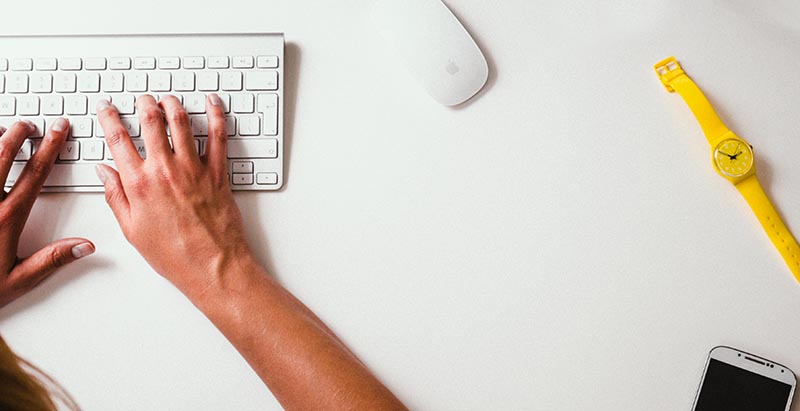 Student filing taxes with keyboard on white desk