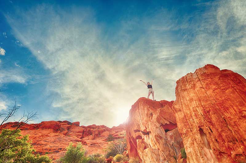 Girl on top of red rock mountains happy