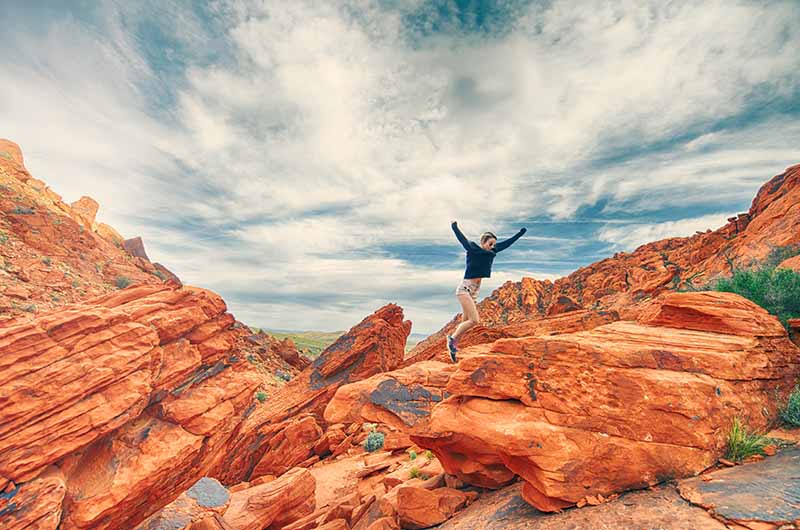 Girl jumping for joy in red rocks