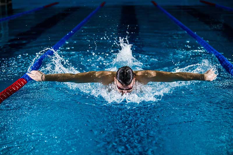 Man swimming toward the camera wearing a swim cap