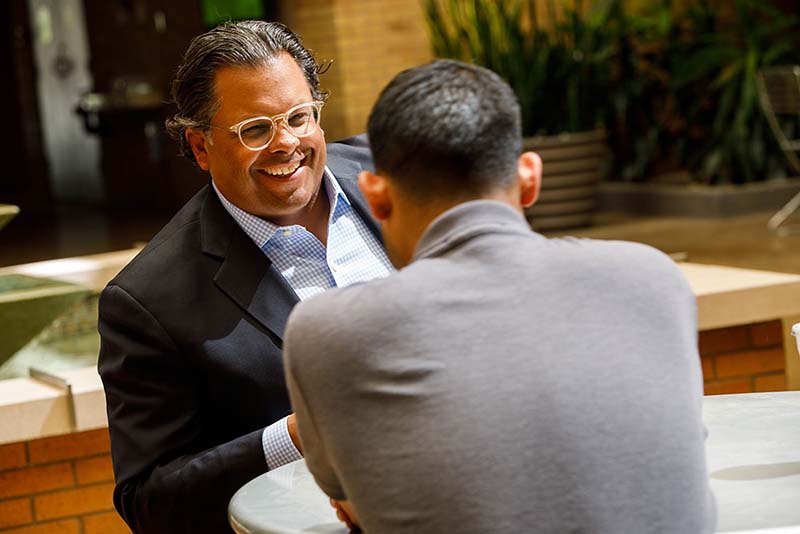 Student and professor laughing and talking together outside