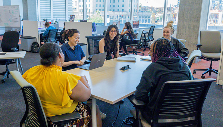Students sitting at a table with laptops.