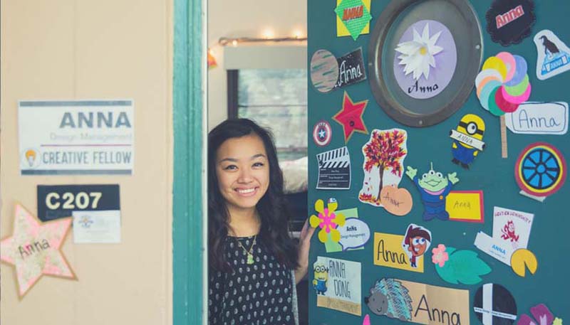 Girl opening the door to her dorm and being welcoming 