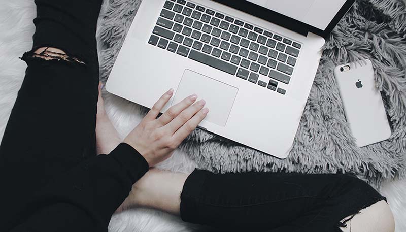 Student using laptop on the floor