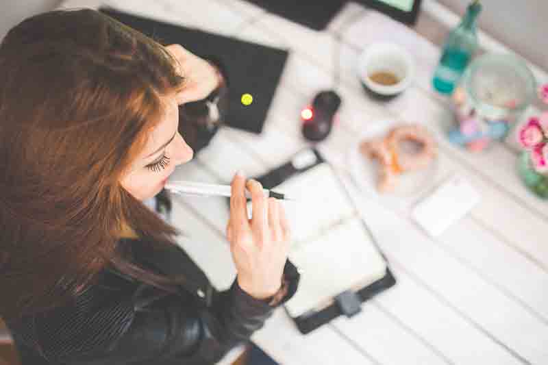 woman thinking while looking at a planner